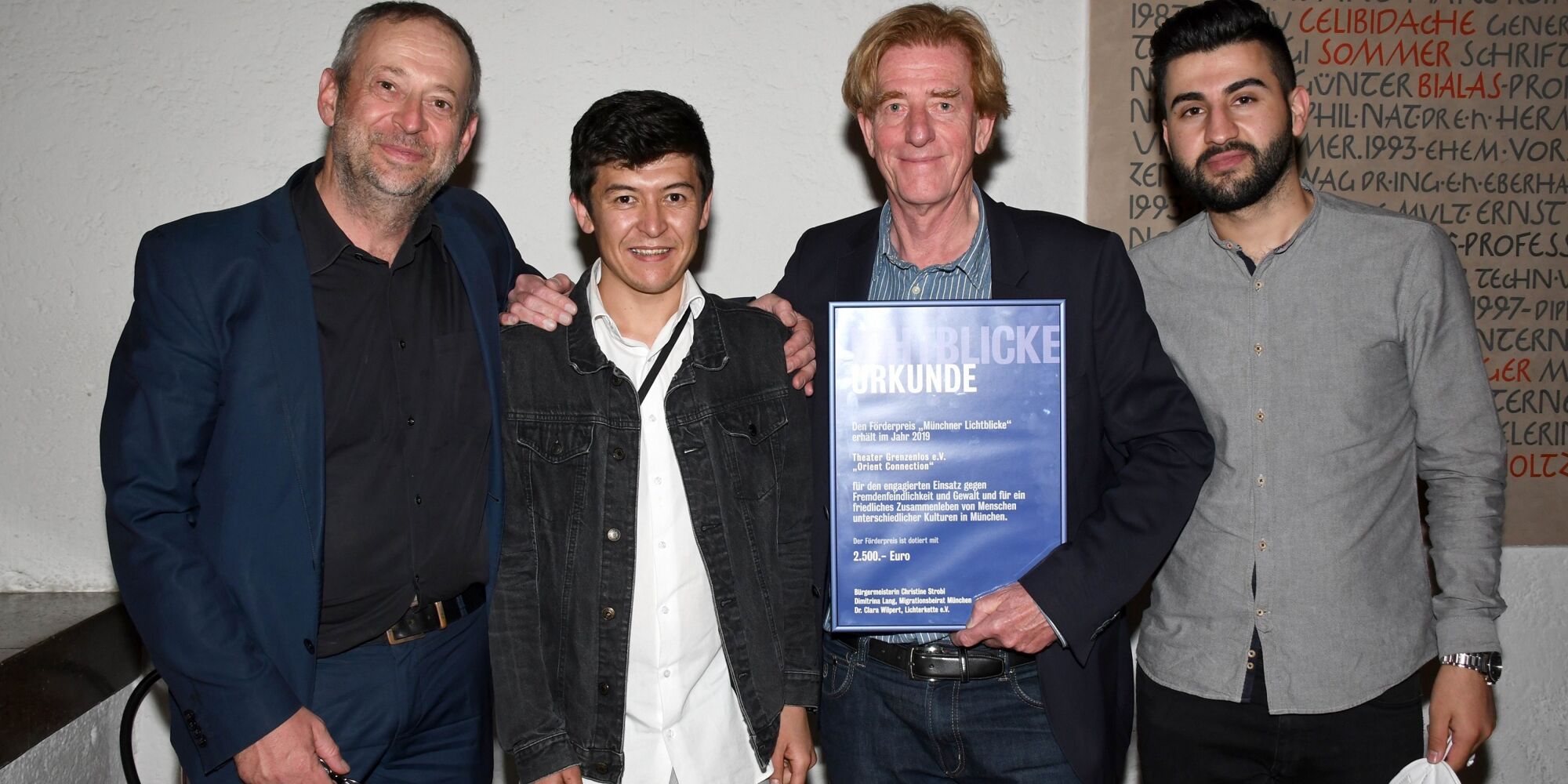 Hier sieht man Julian Franke-Ruthel, Abdul Hakim Rezai, Viktor Schenkel und Hani Ameen Samoo mit der Urkunde für die Auszeichnung "Münchner Lichtblicke".