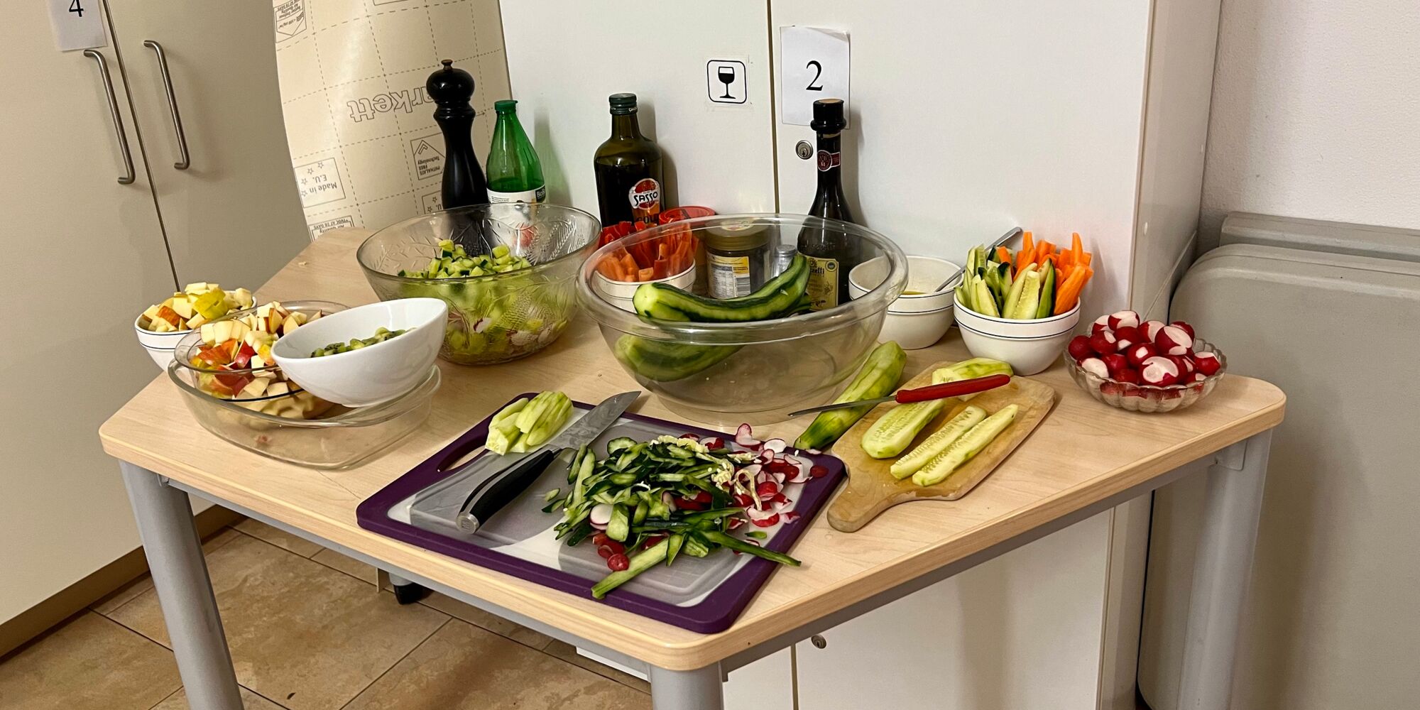 Hier man verschiedenes geschnittenes Obst und Gemüse auf einem Tisch angerichtet.